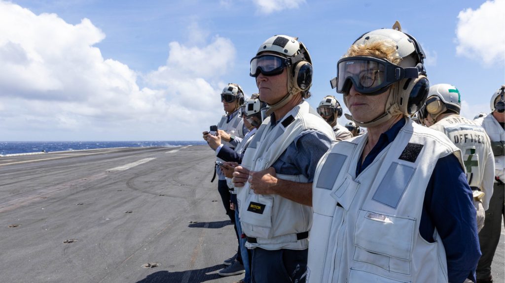 Congressional delegation members in flight deck gear aboard the USS Abraham Lincoln