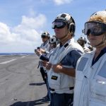 Congressional delegation members in flight deck gear aboard the USS Abraham Lincoln