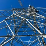 A high-voltage transmission tower against a clear sky.