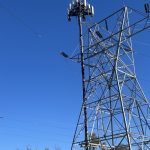 Electricity transmission towers with cell antennas against a blue sky in Chester County, Pennsylvania